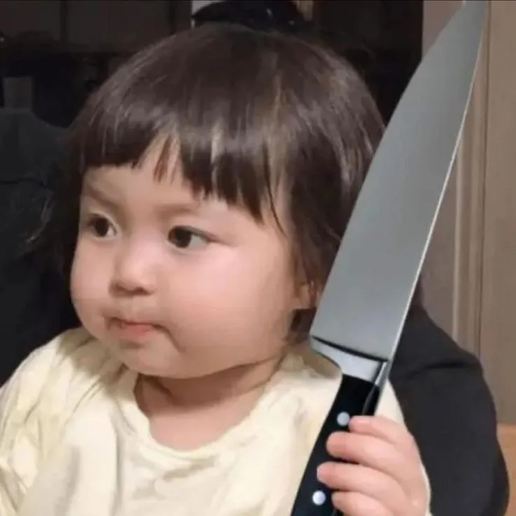 Hình ảnh em bé cầm dao với vẻ mặt troll.
