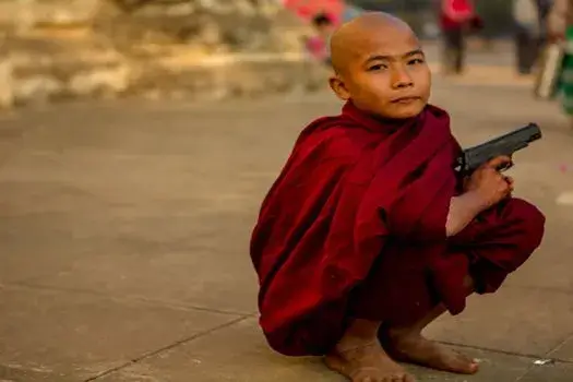 Vị sư nhỏ cầm súng lục trên tay Vị sư nhỏ cầm súng lục trên tay